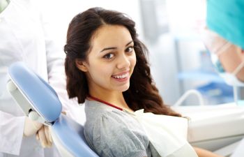 Teenage Girl in Dental Chair Undergoing Fluoride Treatment