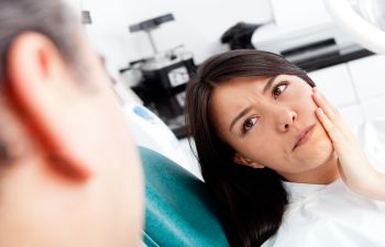 Dentist Talking to a Concerned Woman with a Dental Problem Sitting in a Dental Chair