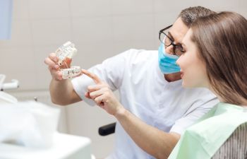 Dentist Showing Dental Model to a Woman Alpharetta, GA
