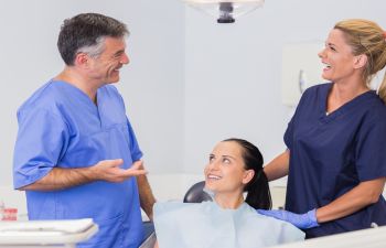 Laughing dentists and a patient in the dentist's office